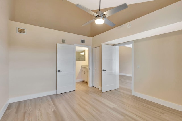 unfurnished bedroom featuring ceiling fan, high vaulted ceiling, ensuite bathroom, light hardwood / wood-style floors, and a closet