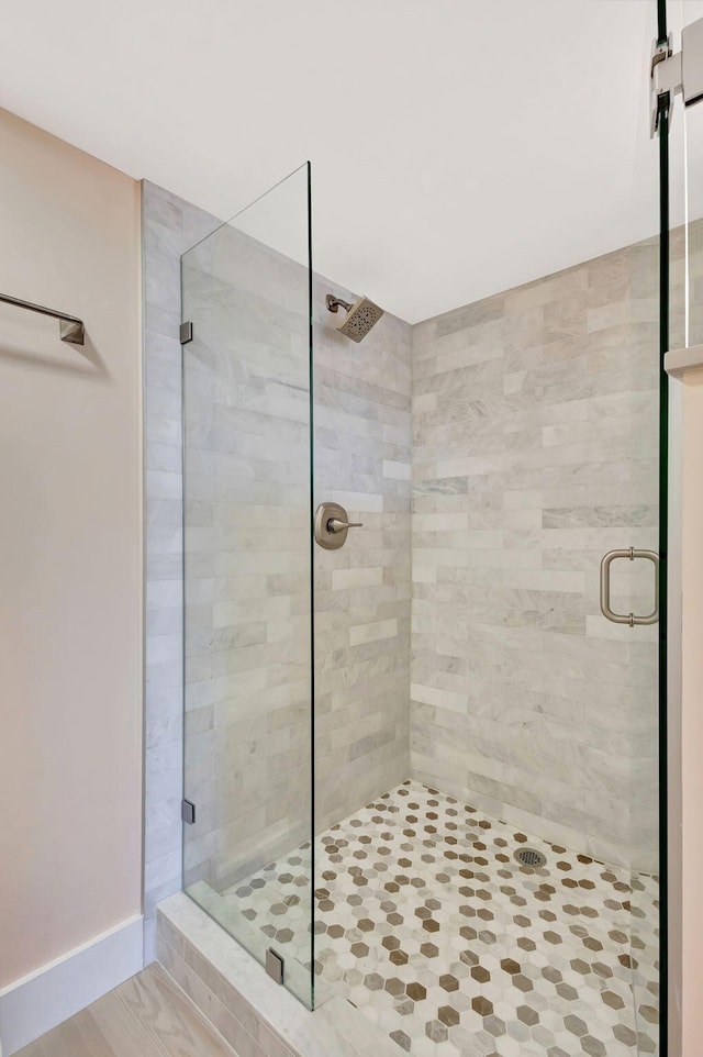 bathroom with hardwood / wood-style floors and an enclosed shower