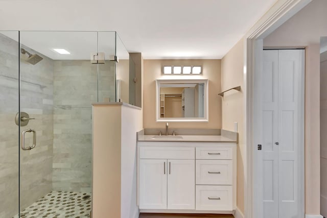 bathroom with vanity and a shower with door