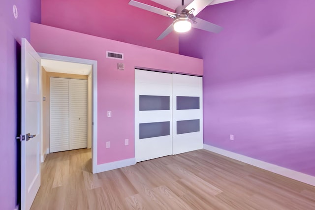 unfurnished bedroom featuring light wood-type flooring, a closet, and ceiling fan