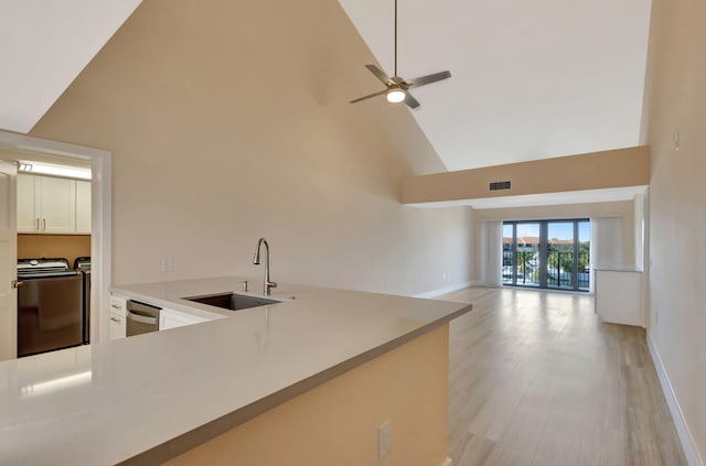 kitchen featuring ceiling fan, washing machine and dryer, sink, and high vaulted ceiling