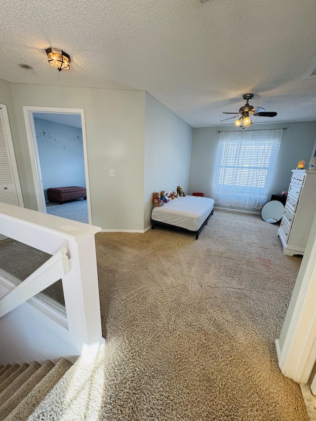 bedroom with carpet, a textured ceiling, and ceiling fan