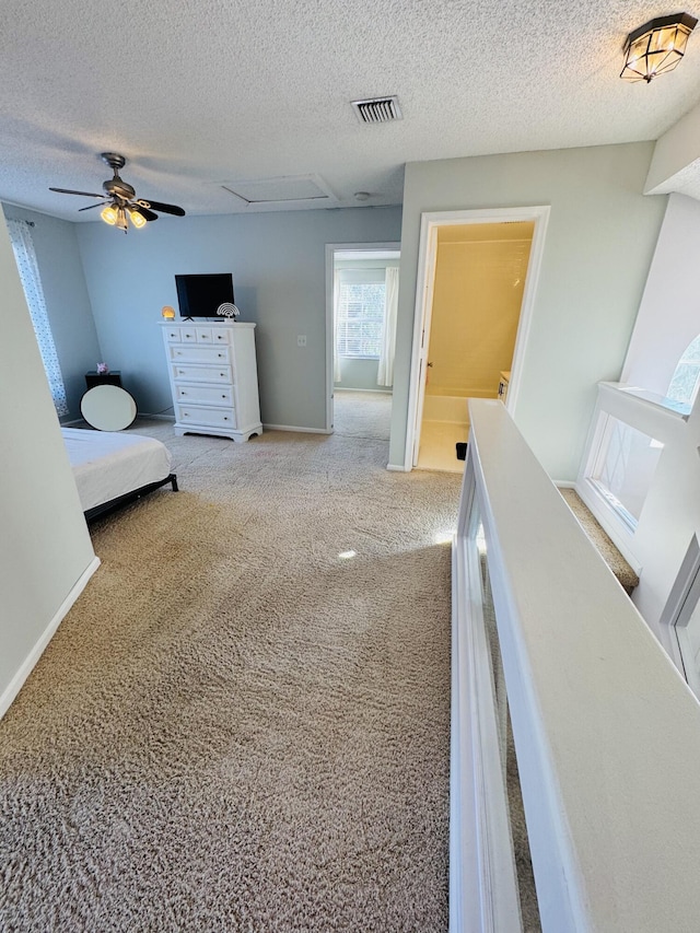 carpeted bedroom featuring a textured ceiling and ceiling fan