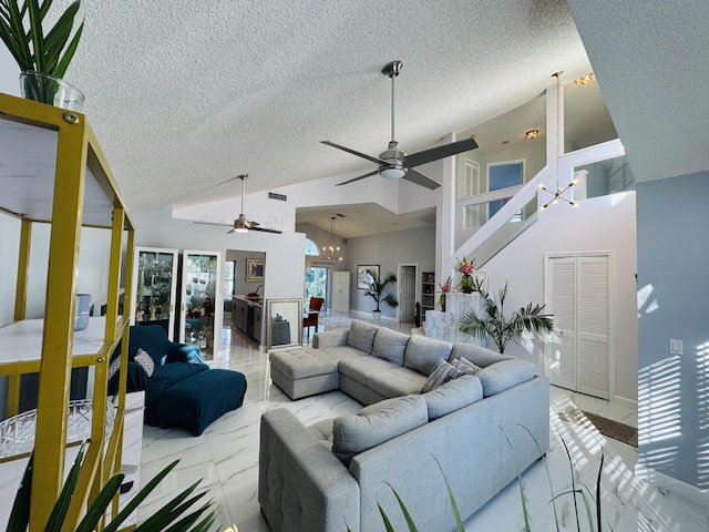 living room featuring ceiling fan with notable chandelier, a textured ceiling, and high vaulted ceiling