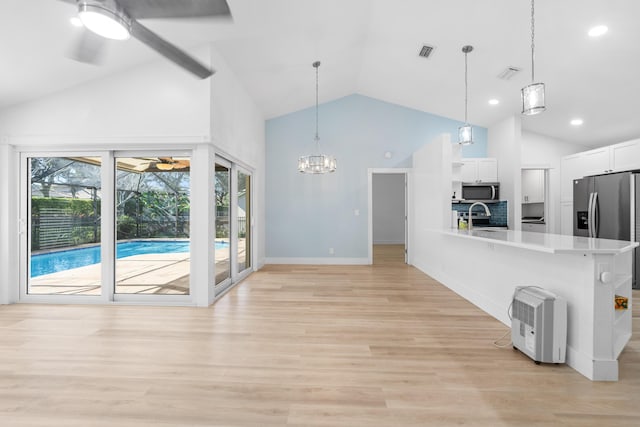 kitchen featuring pendant lighting, white cabinetry, sink, and appliances with stainless steel finishes