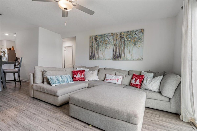 living room with light hardwood / wood-style floors and ceiling fan