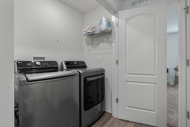 washroom with hardwood / wood-style floors and independent washer and dryer