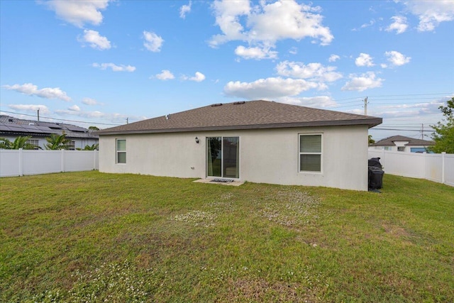 rear view of property featuring a yard