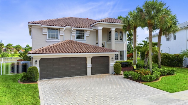 mediterranean / spanish house featuring a front yard and a garage