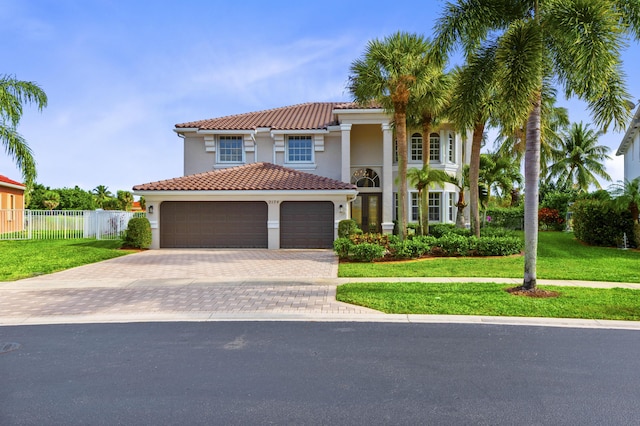 mediterranean / spanish-style house with a garage and a front yard