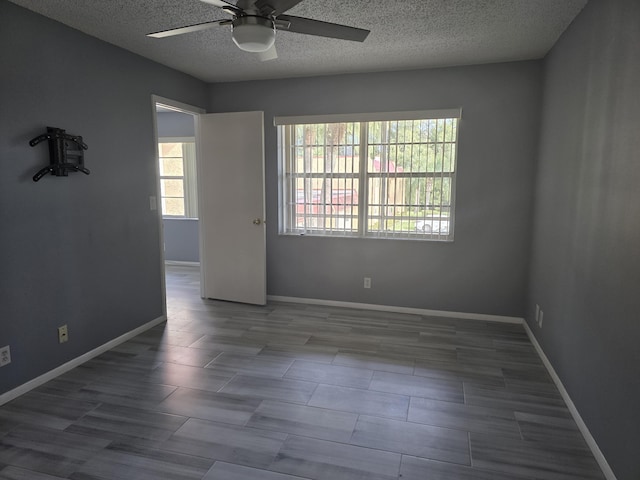 empty room with a textured ceiling and ceiling fan