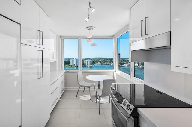 kitchen featuring a water view, white cabinets, and range