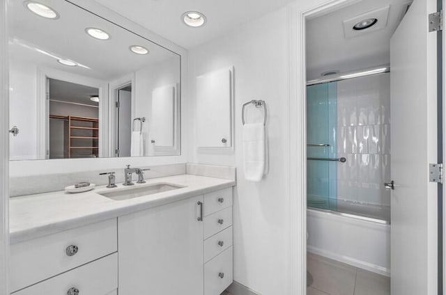 bathroom with combined bath / shower with glass door, vanity, and tile patterned floors