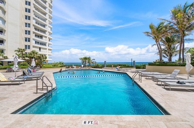 view of pool featuring a patio area and a water view