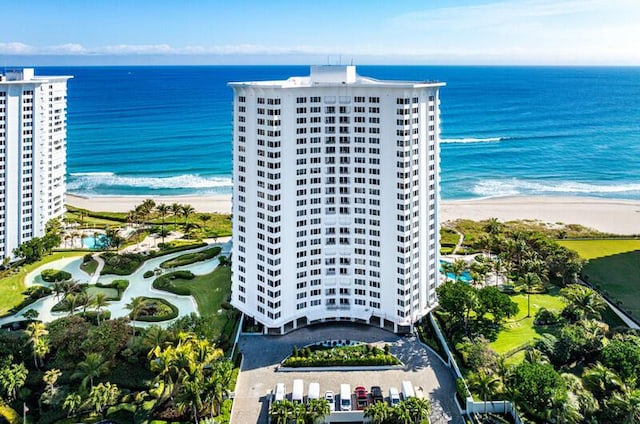 birds eye view of property with a water view and a beach view