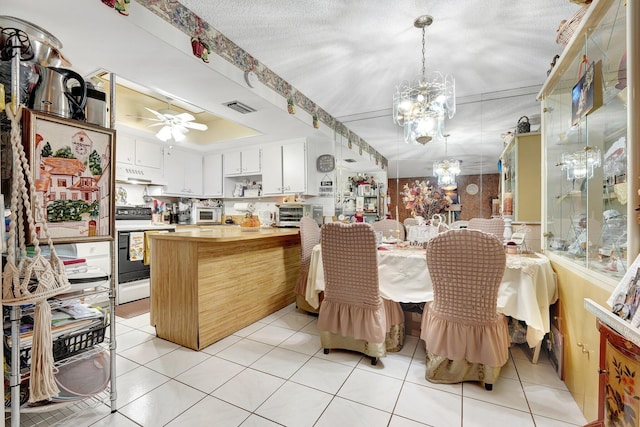 tiled dining area featuring a textured ceiling and ceiling fan