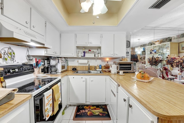 kitchen with white appliances, white cabinetry, a raised ceiling, and sink