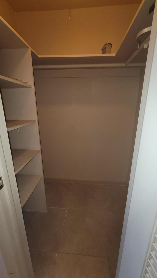 spacious closet featuring dark tile patterned floors