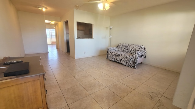 living area with ceiling fan and light tile patterned floors