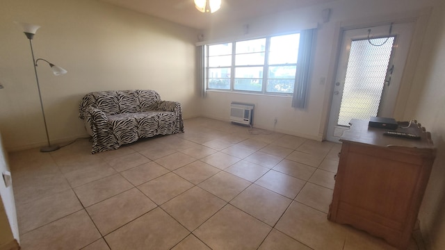 sitting room featuring light tile patterned floors, heating unit, a wall unit AC, and ceiling fan