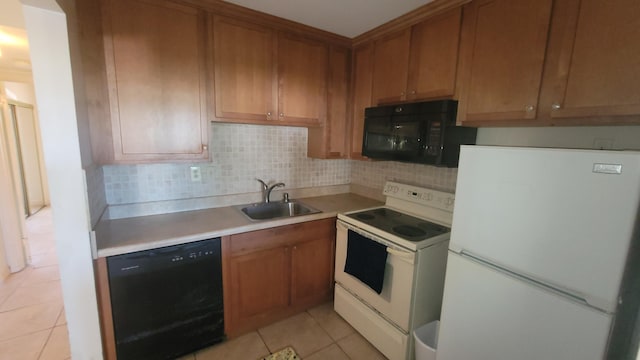 kitchen with backsplash, sink, light tile patterned floors, and black appliances