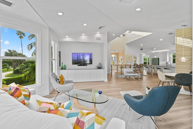 living room with light hardwood / wood-style flooring, wood ceiling, and vaulted ceiling