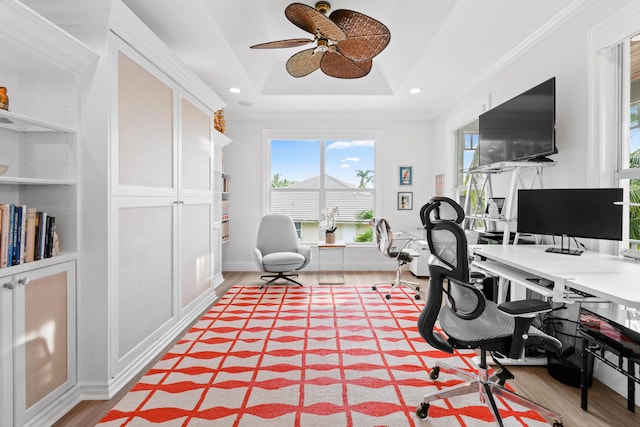 office with ceiling fan, crown molding, hardwood / wood-style flooring, and a tray ceiling