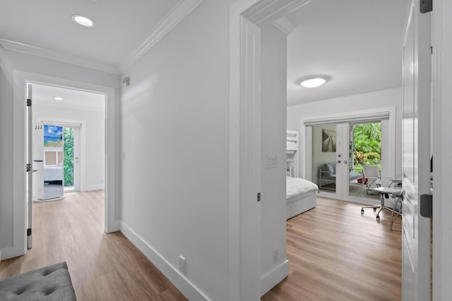 corridor featuring ornamental molding, french doors, and light wood-type flooring