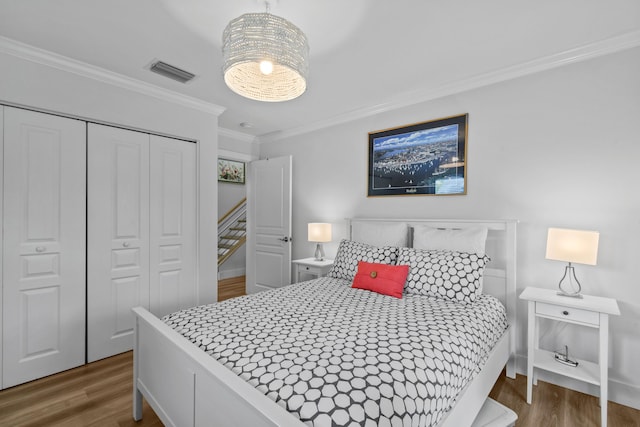 bedroom featuring dark wood-type flooring, a closet, and ornamental molding