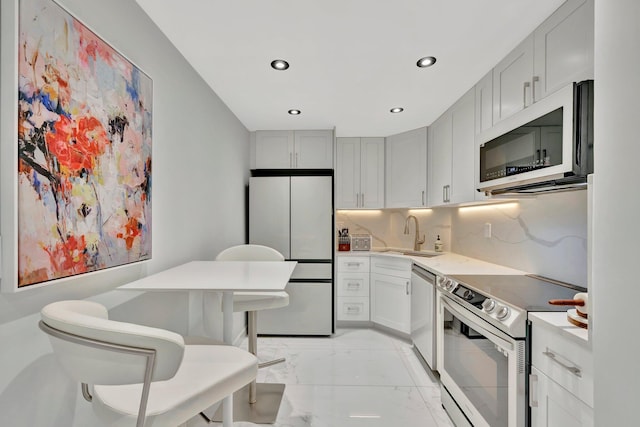 kitchen with a breakfast bar, sink, appliances with stainless steel finishes, and tasteful backsplash