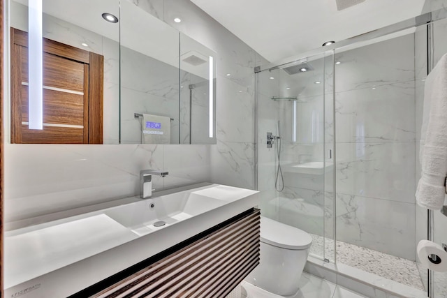 bathroom with vanity, a shower with shower door, tile walls, and toilet