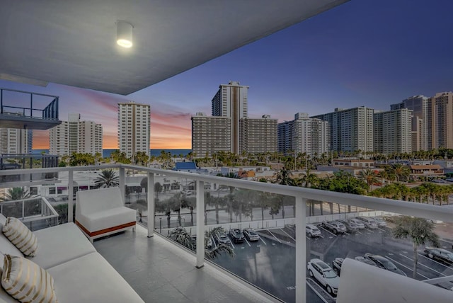 balcony at dusk with outdoor lounge area and a water view