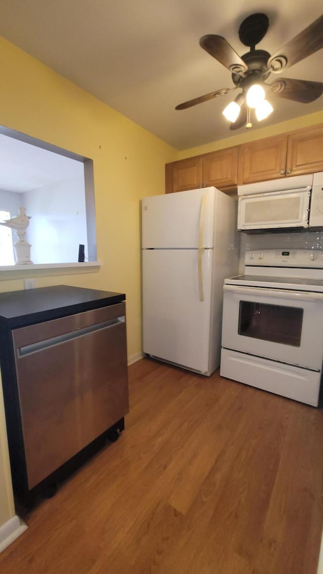 kitchen featuring ceiling fan, white appliances, and hardwood / wood-style flooring