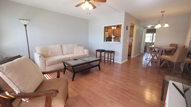 living room with hardwood / wood-style floors and ceiling fan with notable chandelier