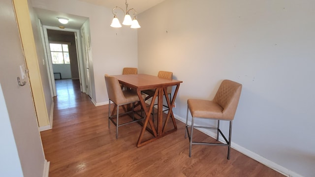 dining space with a notable chandelier and light hardwood / wood-style flooring