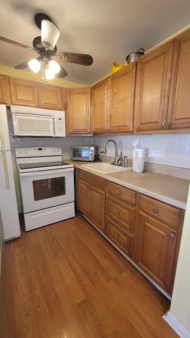 kitchen with ceiling fan, sink, tasteful backsplash, dark hardwood / wood-style flooring, and white appliances