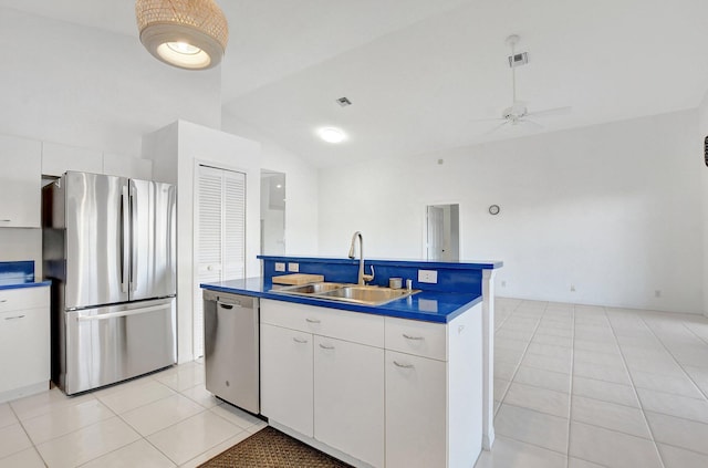 kitchen with ceiling fan, sink, lofted ceiling, white cabinets, and appliances with stainless steel finishes