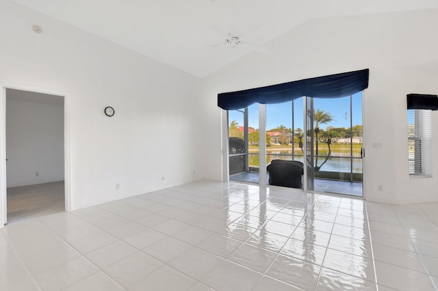 spare room featuring a water view, ceiling fan, light tile patterned floors, and high vaulted ceiling