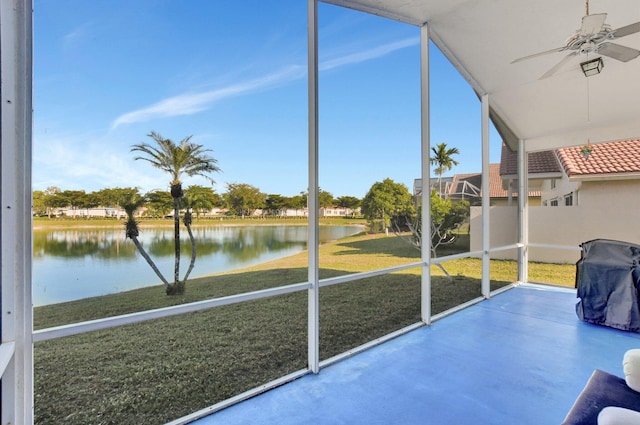 unfurnished sunroom with ceiling fan and a water view