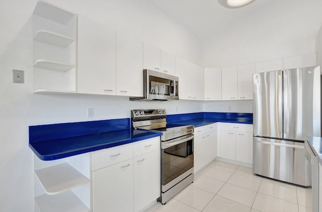 kitchen with white cabinetry, stainless steel appliances, and light tile patterned floors