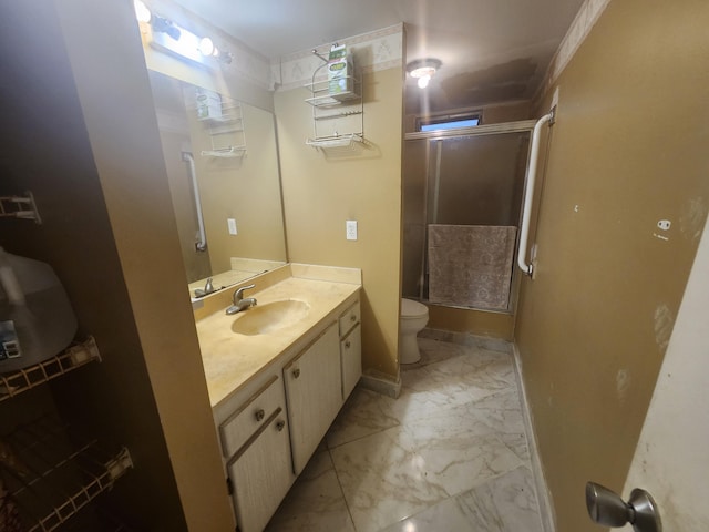 bathroom featuring vanity, toilet, and a shower with shower door