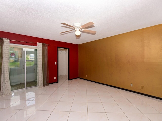 tiled spare room with ceiling fan and a textured ceiling