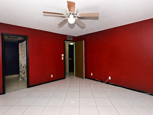 unfurnished room with light tile patterned floors, a textured ceiling, and ceiling fan