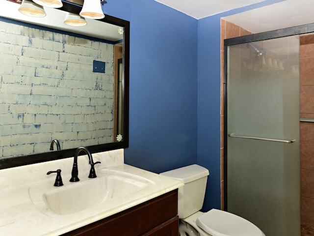 bathroom featuring vanity, an enclosed shower, and toilet