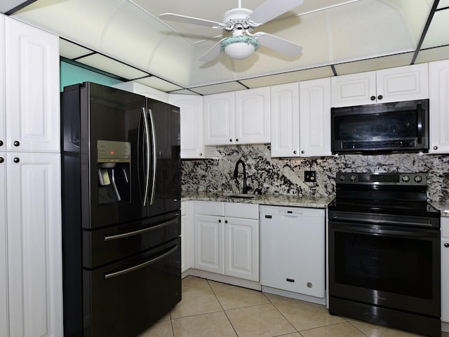 kitchen with black appliances, white cabinets, light stone counters, and tasteful backsplash