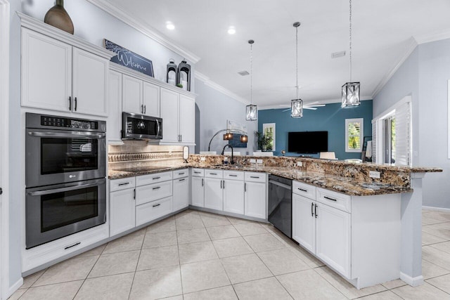 kitchen with appliances with stainless steel finishes, white cabinetry, hanging light fixtures, and sink