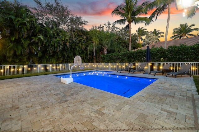 pool at dusk with a patio