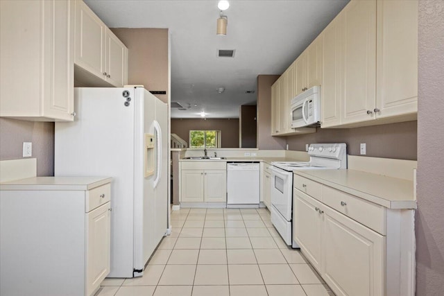 kitchen with light tile patterned flooring, white appliances, kitchen peninsula, and sink