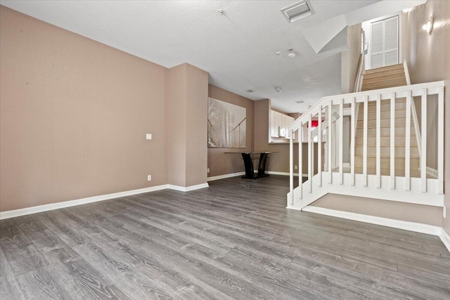 unfurnished living room with a textured ceiling and hardwood / wood-style flooring