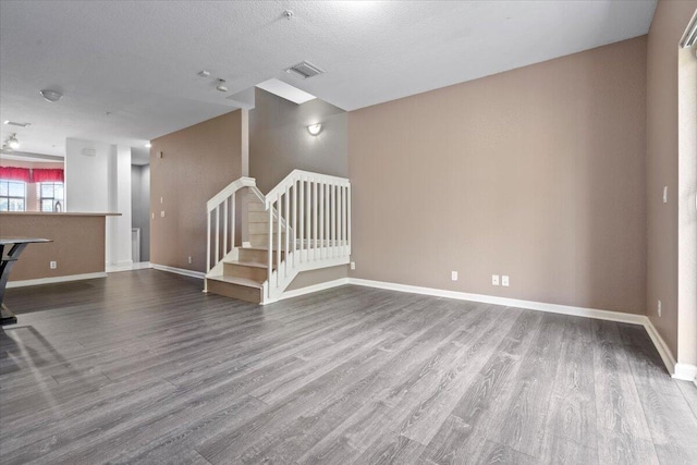 interior space featuring wood-type flooring and a textured ceiling